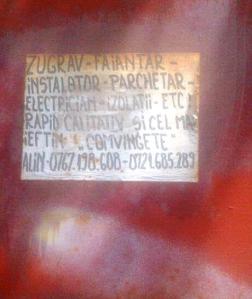 Anunţ vechi de când lumea, al unui zugrav, faianţer şamd, fotografiat cu telefonul pe o poartă de tablă de pe strada Polonă din Bucureşti. Foto: Călin Hera