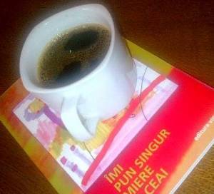 Cană de cafea într-o ceaşcă normală, aşezată pe-o carte. FOTO (cu telefonul): Călin Hera