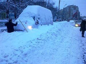 Şoferul microbuzului înzăpezit munceşte dis-de-dimineaţă. Foto (cu telefonul): Călin Hera