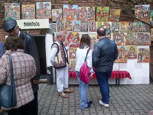 Muzeul Ţăranului Român, de Florii 2014. Picturi naive şi bărbat în costum popular. Foto cu telefonul: Călin Hera