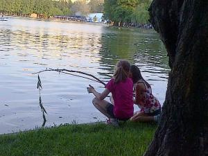 Vedere din Bucureşti. Două fetiţe "pescuiesc" la malul lacului IOR. Foto: Călin Hera (cu telefonul)