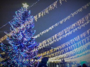 Vedere din București. Înghesuială de weekend, dâre de lumină și brad în Târgul de Crăciun, zona statuilor de la Universitate. Foto cu telefonul: Călin Hera 